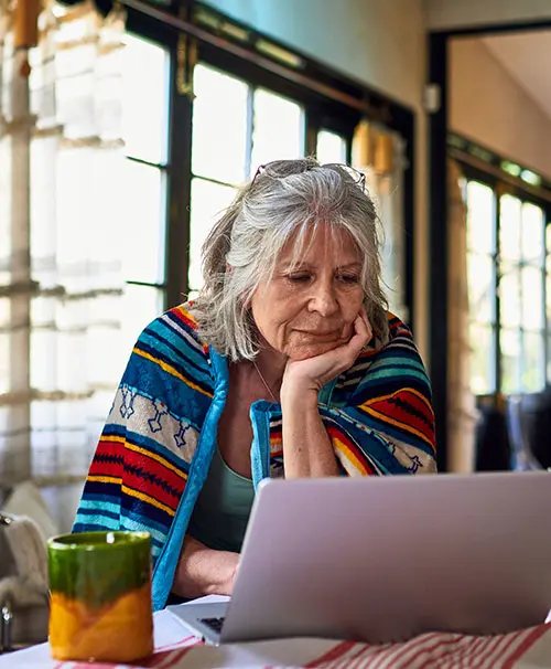 Lady looking at laptop with a serious expression