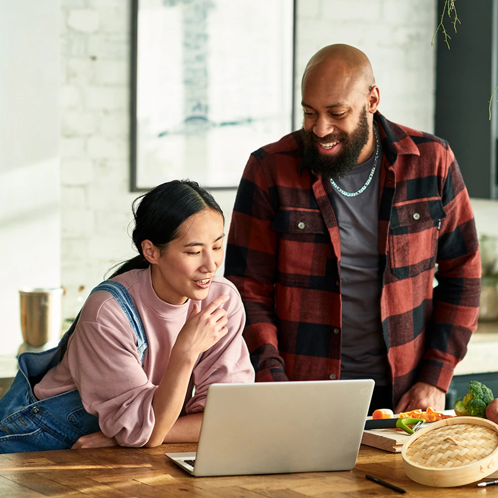 Man and woman looking at laptop smiling